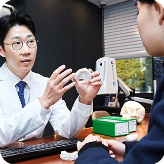 치아 모형을 보며 치료 내용을 설명하는 박홍식 원장
