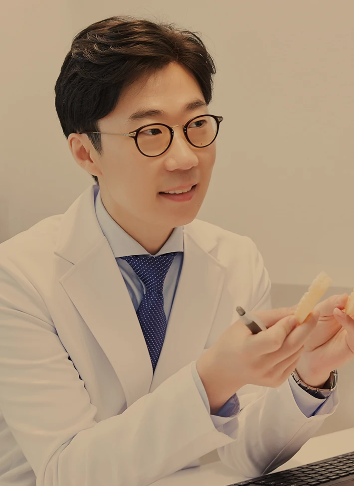 치아 모형을 들고 설명하는 박홍식 원장